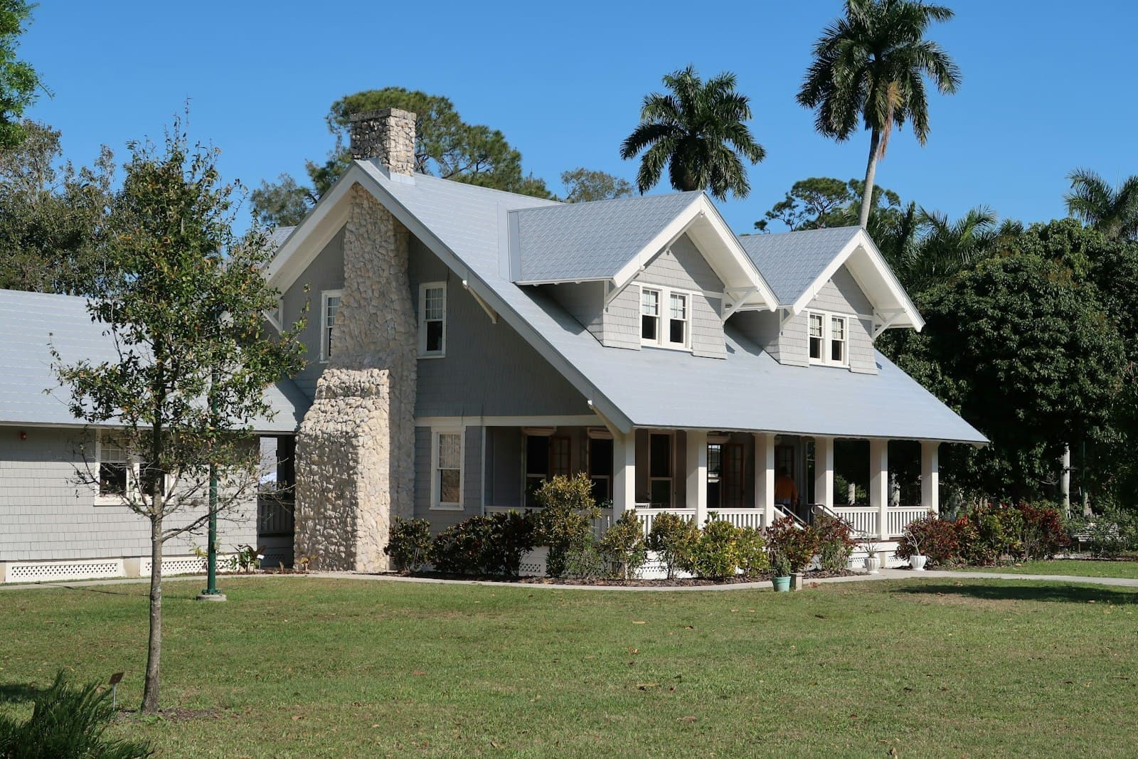 A Florida home with a wraparound porch shaded by palm trees